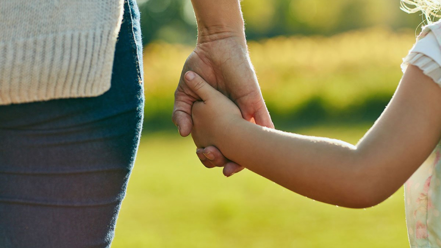 Cropped shot of a little girl holding an unrecognizable woman’s hand in the park